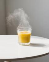 A glass of orange juice with steam coming out of it photo