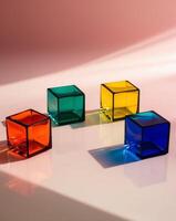 Four Colorful Glass Cubes on Pink Surface. photo