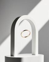 A white pedestal with a gold ring sits beneath a white circular arch. photo