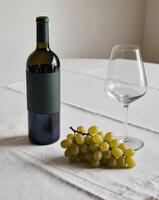 A bottle of wine and a glass of wine on a table photo