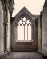 An old church with a window and a stone wall photo