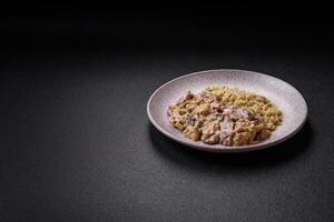 Bowl of food with beef, bulgur, tomatoes, zucchini and sauce photo