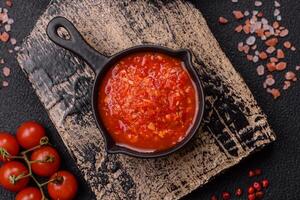 Delicious hot spicy red sauce with salt and spices in a ceramic bowl photo