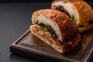 Ciabata with jamon or prosciutto, tomatoes, cheese and lettuce photo
