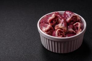 Raw chicken hearts with salt, spices and herbs photo