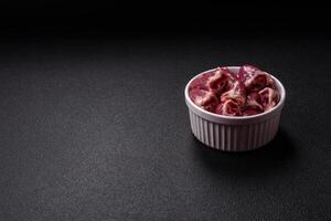 Raw chicken hearts with salt, spices and herbs photo