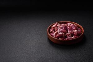 Raw chicken hearts with salt, spices and herbs photo