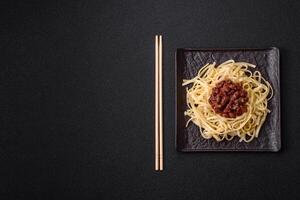 Rice noodles with beans, meat, tomato sauce, spices and herbs photo