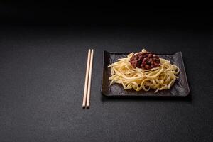 Rice noodles with beans, meat, tomato sauce, spices and herbs photo