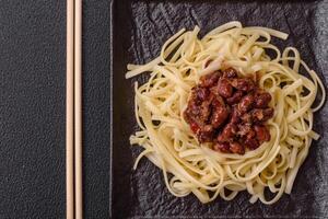 Rice noodles with beans, meat, tomato sauce, spices and herbs photo