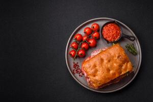Focaccia with salami, cheese, tomatoes, arugula, salt, spices and herbs photo