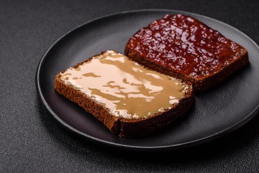Sandwiches with toast bread, peanut butter and raspberry or strawberry jam photo