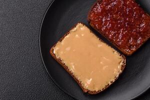 Sandwiches with toast bread, peanut butter and raspberry or strawberry jam photo