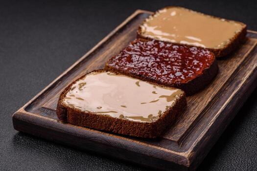 Sandwiches with toast bread, peanut butter and raspberry or strawberry jam photo