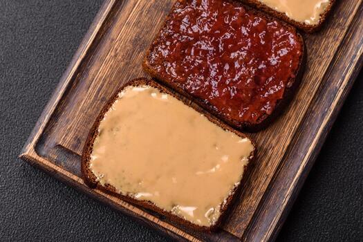 Sandwiches with toast bread, peanut butter and raspberry or strawberry jam photo