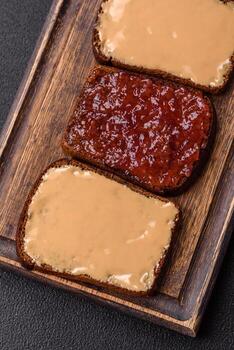 Sandwiches with toast bread, peanut butter and raspberry or strawberry jam photo