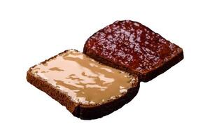 Sandwiches with toast bread, peanut butter and raspberry or strawberry jam photo