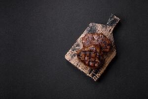 Juicy beef steak baked on the grill with salt, spices and herbs photo