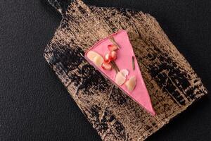 Piece of sweet cheesecake with pink cream cheese of raspberry or strawberry flavor photo