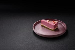 Piece of sweet cheesecake with pink cream cheese of raspberry or strawberry flavor photo