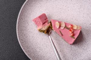 Piece of sweet cheesecake with pink cream cheese of raspberry or strawberry flavor photo