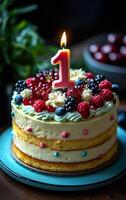 A cake with a lit candle on top and berries and frosting. The cake is decorated with a number 1 and a pink candle photo