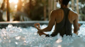 A yogi sitting in a tub filled with ice focusing on deep breathing to reduce the shock of the cold water on their body photo