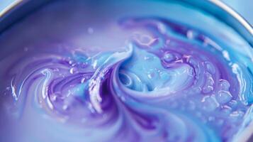 A macro shot of a delicate handpoured soy wax candle revealing the intricate swirls of vibrant purple and blue dye throughout photo