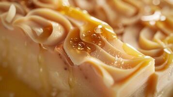 A closeup shot of a slice of handmade soap highlighting the smooth and velvety texture of the soaps top layer which is made of whipped cocoa butter and drizzled with honey. The soa photo