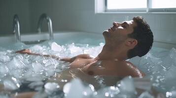 A man sitting in a bathtub filled with ice his chest rising and falling rhythmically as he practices controlled breaths photo