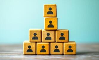 A stack of wooden blocks with people on them. The blocks are stacked on top of each other, with the bottom block having the most people and the top block having the least. photo