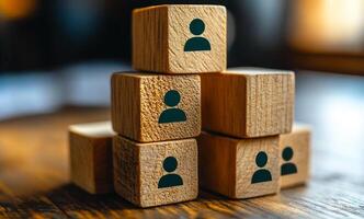 A stack of wooden blocks with people on them. The blocks are arranged in a pyramid shape. Concept of teamwork and collaboration, as the people on the blocks are working together to build something. photo
