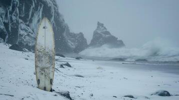 A surfboard stands upright against a snowcovered cliff its owner nowhere in sight as he takes a break from the frigid conditions photo