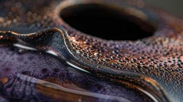 The depth and dimension of a ceramic pitcher with layers of deep purple glaze intermixed with touches of metallic copper and black photo