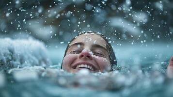 A person emerging from the water with a triumphant smile surrounded by chunks of ice and snowflakes photo