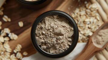 A small pot of facial scrub filled with earthy ingredients like oats clay and finely ground almond powder highlighting the grainy and exfoliating texture photo