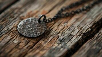 A closeup of a handstamped pendant reveals the small careful hammer marks and blackened edges giving it a unique rustic look photo