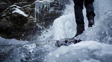 A person standing on the edge of a partially frozen waterfall preparing to take a dip in the icy waters below photo