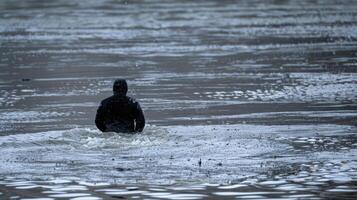 A lone figure stands waistdeep in the frigid water a look of determination on their face photo