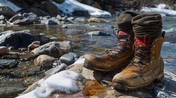 A pair of hiking boots and socks drying in the sun on a flat rock having been soaked through during a trek through a frigid mountain stream photo