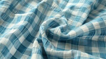 An upclose view of a vintage gingham fabric with small checks in light blue and white. The slightly faded and uneven colors give the fabric a charming wellloved quality photo