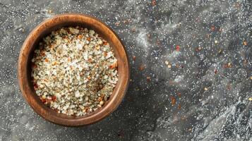 An overhead view of a small wooden bowl filled with a medley of co and finely ground es. The fine particles have settled at the bottom creating a layered effect with the larger piece photo