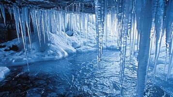 Heavy icicles hanging over a shallow ice pool creating a natural ice cave for visitors to explore photo