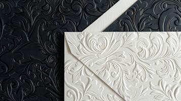 A minimalist yet opulent black and white envelope featuring a pattern of intricate embossed flourishes perfect for mailing out special announcements photo