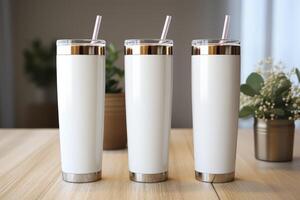 Three white tumblers with straws sitting on a table photo