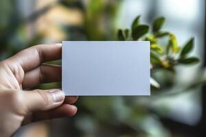 A person holding a blank piece of paper in front of a plant photo