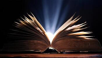 An open book emits bright, glowing light rays from its pages, creating a magical and inspiring atmosphere in the darkness. photo