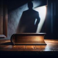 A dramatic scene with a large book on a wooden table, casting a shadow of a man on the wall in dim light. photo