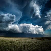 Massive dark storm clouds roll over a wide, open field, creating a dramatic and moody atmosphere in a rural landscape. photo