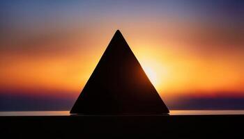 Geometric pyramid silhouette framed by a glowing sunset, creating a striking contrast between the dark shape and colorful sky. photo